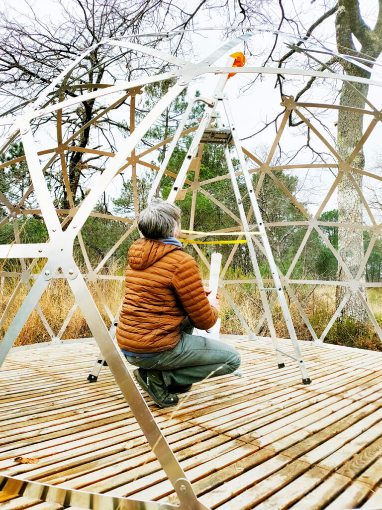 Homme qui monte un dôme géodésique en aluminium